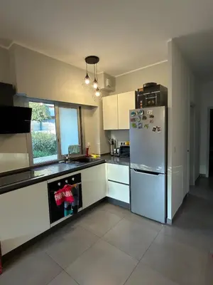a kitchen with white cabinets and a refrigerator at Superbe Appartement 2 pièces - 39m2 in Cannes