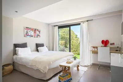 a bedroom with a large bed and a large window at Villa Baie Des Iles in Cannes