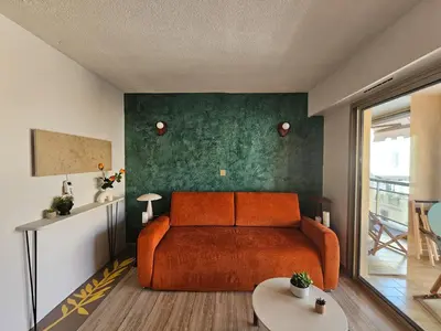 an orange bed in a room with a green wall at Volt ' palm in Cannes