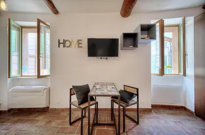 a room with a table and two chairs and a tv at Agréable Studio quartier Suquet-Vieux Port A0B185 in Cannes