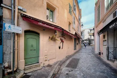 an alley with a green door on a building at Agréable Studio quartier Suquet-Vieux Port A0B185 in Cannes