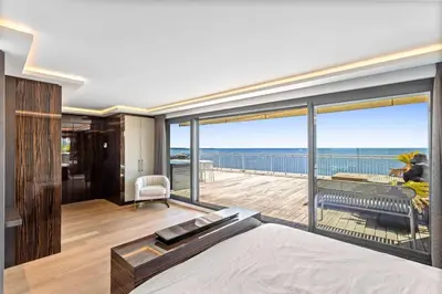 a bedroom with a bed and a view of the ocean at REF 2043 - Cannes Penthouse with panoramic sea view for rent in Cannes