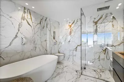 a bathroom with a white tub and marble walls at REF 2043 - Cannes Penthouse with panoramic sea view for rent in Cannes