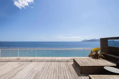 a balcony with a view of the ocean and a pool at REF 2043 - Cannes Penthouse with panoramic sea view for rent in Cannes
