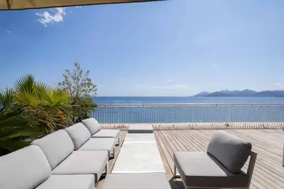 a living room with a couch and a view of the ocean at REF 2043 - Cannes Penthouse with panoramic sea view for rent in Cannes