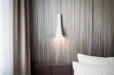 a room with a bed and a lamp on the wall at OKKO Hotels Cannes Centre in Cannes