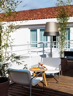 a patio with a table and chairs on a deck at OKKO Hotels Cannes Centre in Cannes