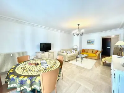 a living room with a table and a couch at Cannes Center by Welcome to Cannes in Cannes