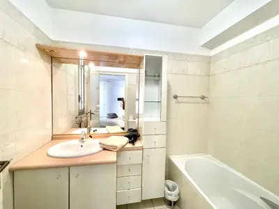 a bathroom with a sink and a tub and a mirror at Cannes Center by Welcome to Cannes in Cannes