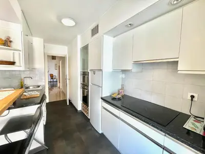 a kitchen with white cabinets and black counter tops at Cannes Center by Welcome to Cannes in Cannes