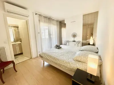 a bedroom with a bed and a table with a lamp at Cannes Center by Welcome to Cannes in Cannes