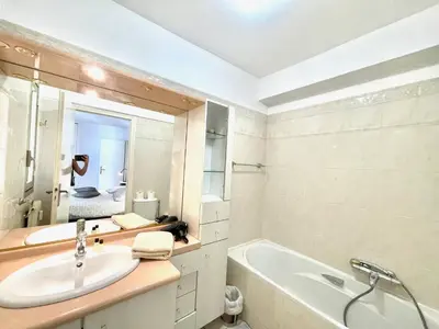 a bathroom with a sink and a tub and a mirror at Cannes Center by Welcome to Cannes in Cannes
