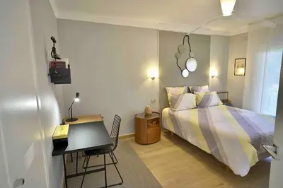 a bedroom with a bed and a desk and a table at Appartement chic à Cannes, avec terrasse et cheminée, 83 m² in Cannes