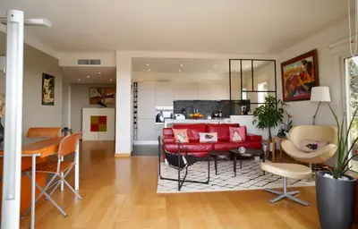a kitchen and a living room with a red couch at Appartement chic à Cannes, avec terrasse et cheminée, 83 m² in Cannes