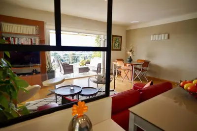 a living room with a red couch and a table at Appartement chic à Cannes, avec terrasse et cheminée, 83 m² in Cannes