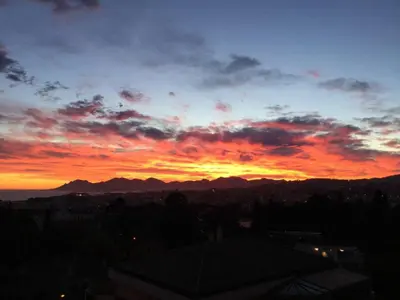 a sunset over a city with mountains in the background at Appartement chic à Cannes, avec terrasse et cheminée, 83 m² in Cannes