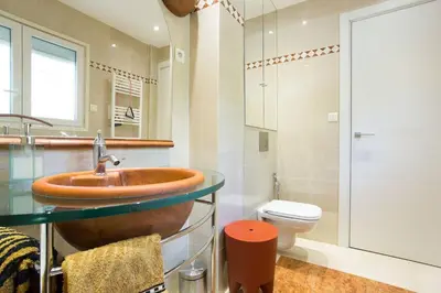 a bathroom with a copper sink and a toilet at Appartement chic à Cannes, avec terrasse et cheminée, 83 m² in Cannes