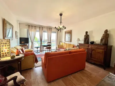 a living room with an orange couch and a tv at Méditerranée by Welcome to Cannes in Cannes