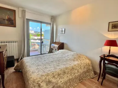 a bedroom with a bed and a large window at Méditerranée by Welcome to Cannes in Cannes
