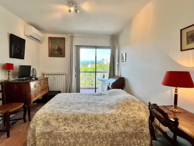 a bedroom with a bed and a desk and a window at Méditerranée by Welcome to Cannes in Cannes