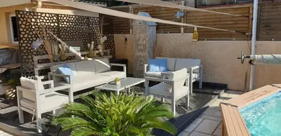 a patio with white furniture and a swimming pool at Le Calme au Centre Ville à 10 minutes à pied de la Croisette et des plages in Cannes