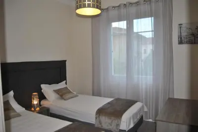 a bedroom with two beds and a window at Le Calme au Centre Ville à 10 minutes à pied de la Croisette et des plages in Cannes