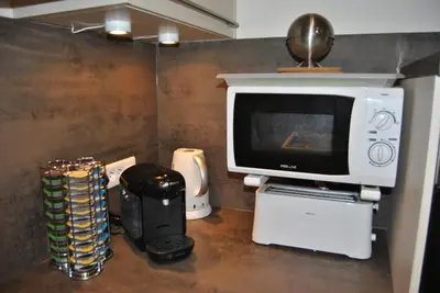 a tv sitting on a counter next to a microwave at Le Calme au Centre Ville à 10 minutes à pied de la Croisette et des plages in Cannes