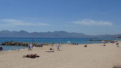 a group of people on a beach near the water at Appartement Loft Cannes in Cannes
