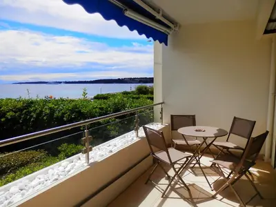 a balcony with a table and chairs and a view of the water at Apartment Lerins by Interhome in Cannes