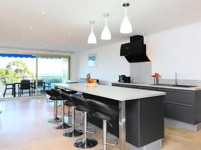 a kitchen with a large island with black bar stools at Apartment Lerins by Interhome in Cannes