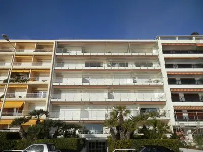 an apartment building with palm trees in front of it at Apartment Lerins by Interhome in Cannes