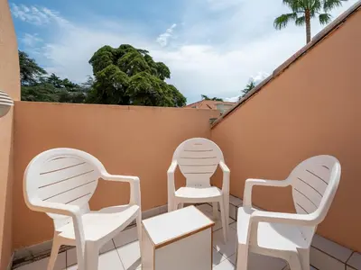 two white chairs and a table on a balcony at Apartment Villa Francia-5 by Interhome in Cannes