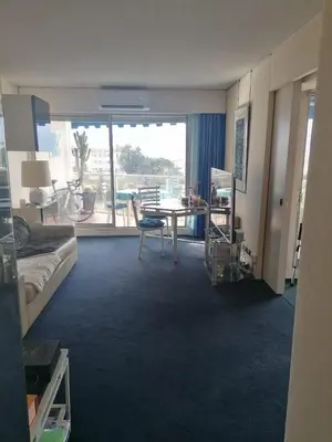 a hotel room with a table and a view of a balcony at CANNES CROISETTE Sea & Sky in Cannes
