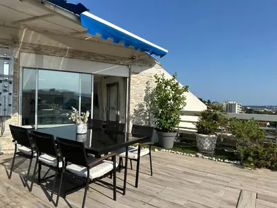 a black dining table and chairs on a patio at CANNES CROISETTE Sea & Sky in Cannes