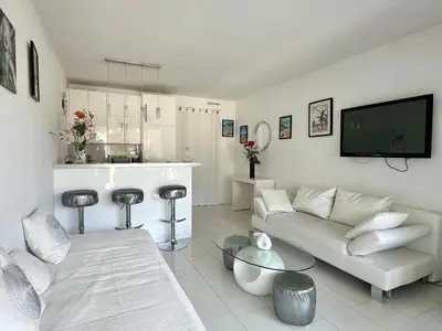 a white living room with a couch and a kitchen at CANNES CROISETTE Sea & Sky in Cannes