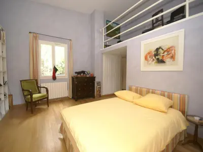 a bedroom with a bed and a chair and a window at Scenic villa in Cannes with private pool in Cannes