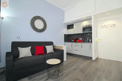 a living room with a black couch and a table at ALC - MOL6 - 9 min Palais and 5 min Beaches in Cannes