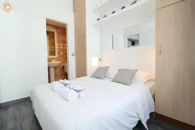 a bedroom with a white bed with towels on it at ALC - MOL6 - 9 min Palais and 5 min Beaches in Cannes