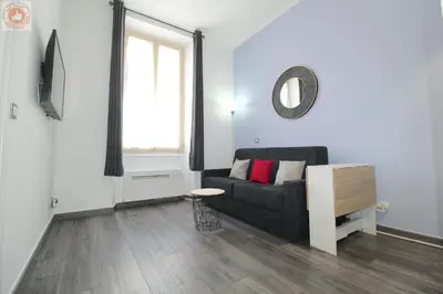 a living room with a black couch and a window at ALC - MOL6 - 9 min Palais and 5 min Beaches in Cannes