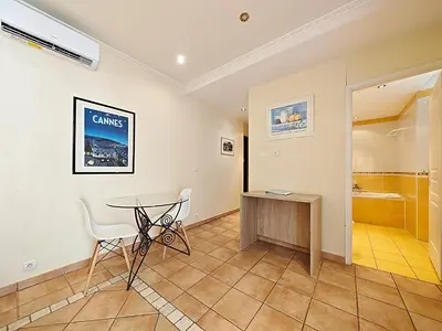 a room with a table and chairs and a walk in shower at Viva Riviera Residence Commandant André in Cannes