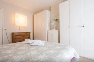 a bedroom with a large bed with white cabinets at Large 1 Bedroom with Balcony City Centre in Cannes