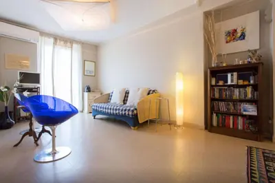 a living room with a blue chair and a couch at Large 1 Bedroom with Balcony City Centre in Cannes