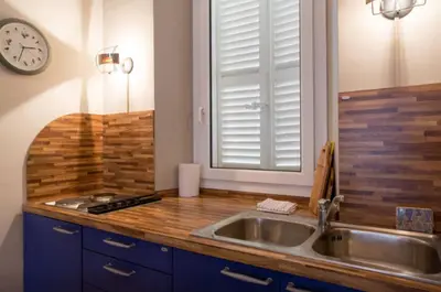 a kitchen with a sink and a clock on the wall at Large 1 Bedroom with Balcony City Centre in Cannes