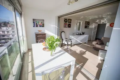 a living room with a table with a vase on it at Central Park by Connexion in Cannes