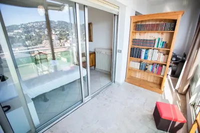a room with glass doors and a book shelf with books at Central Park by Connexion in Cannes