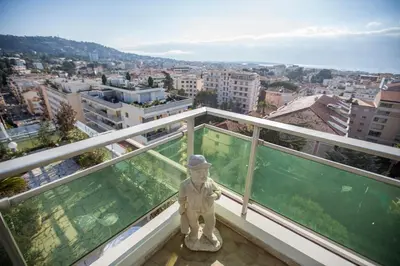 a statue on a balcony with a view of a city at Central Park by Connexion in Cannes