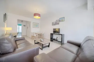 a living room with a couch and a table at IMMOGROOM - Renovated apartment - Terrace - AC in Cannes