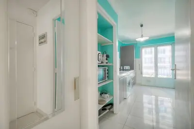 a kitchen with blue walls and a white floor at IMMOGROOM - Renovated apartment - Terrace - AC in Cannes