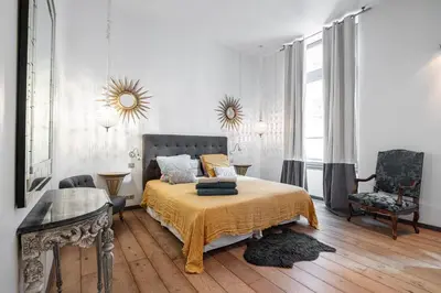 a bedroom with a bed and a table and a chair at The Cosmopolitan Lodge in Cannes