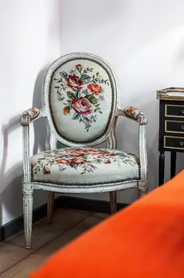 a chair with a floral seat in a room at The Cosmopolitan Lodge in Cannes